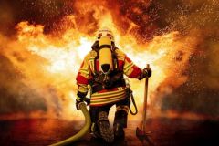 Feuerwehrmann kniet vor einem Feuer Feuerwehrmann kniet vor einem Feuer